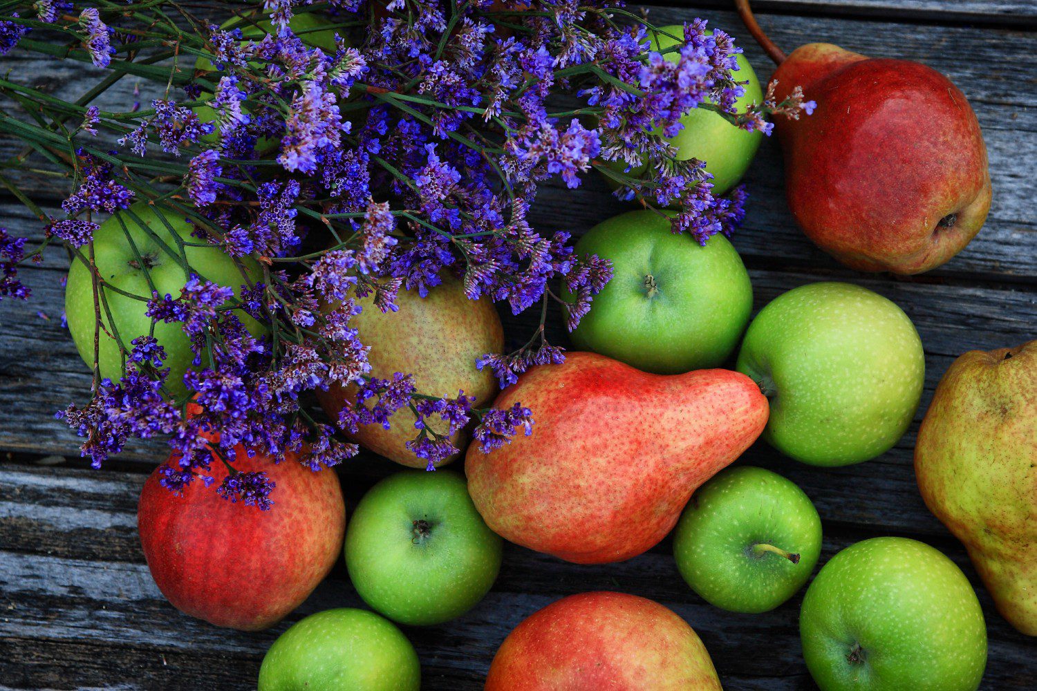 Colorful fruits and flowers on wooden table