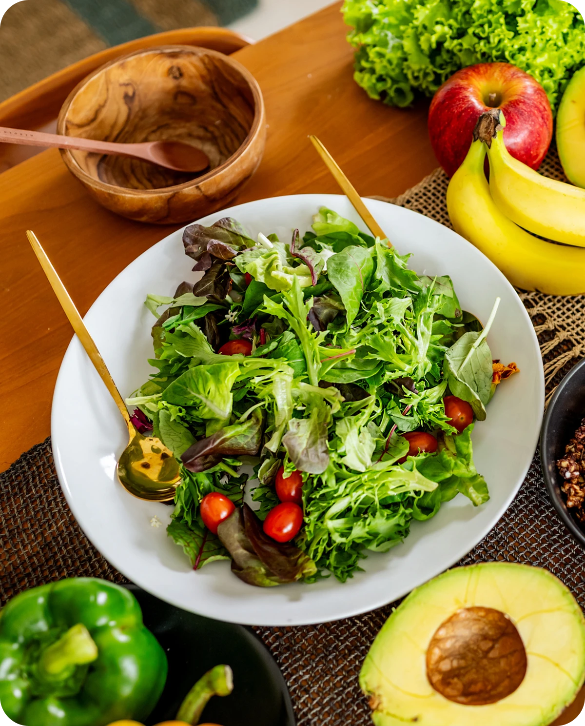 Healthy salad surrounded by fresh fruits