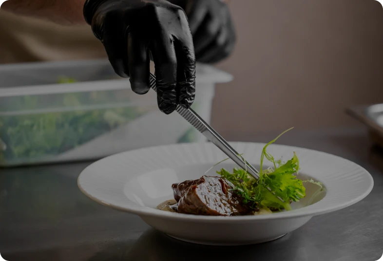 Culinary presentation with black gloves
