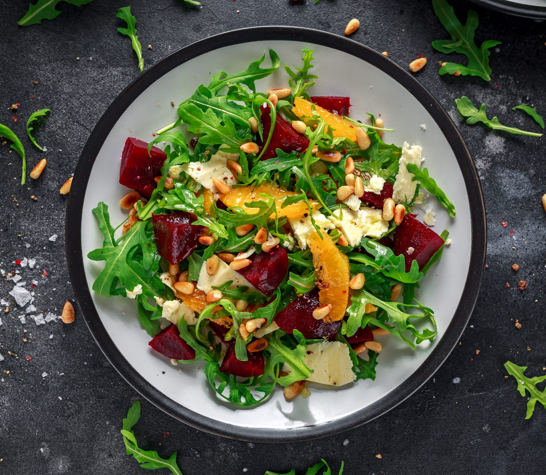 Fresh mixed salad with greens, beets, oranges, and nuts.