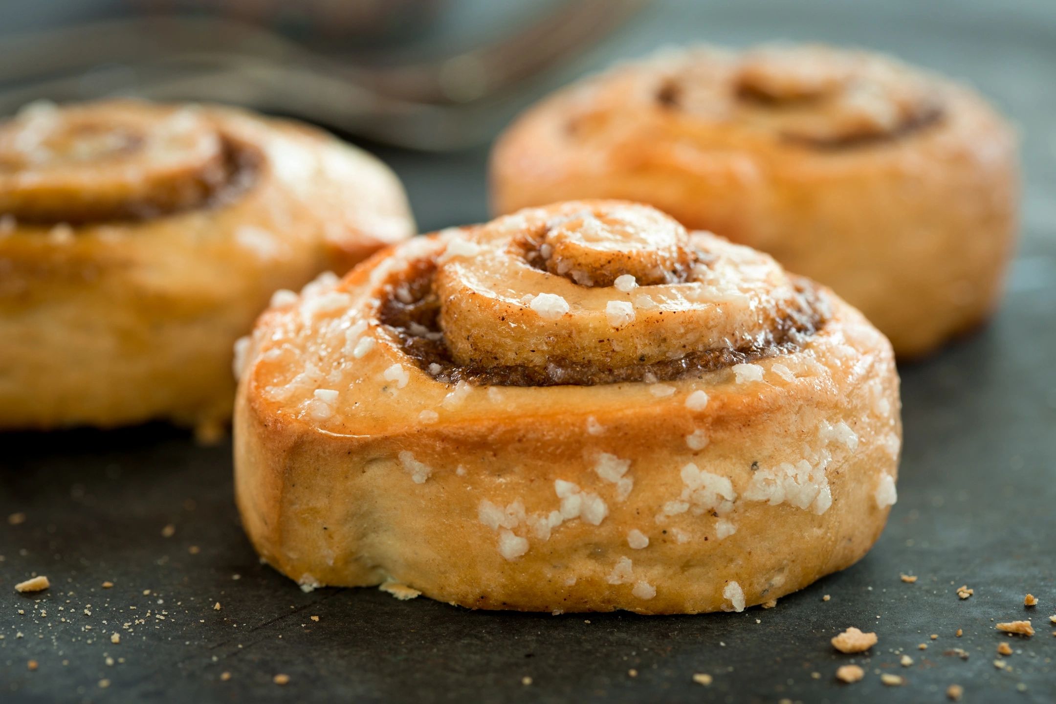 Close-up of freshly baked cinnamon rolls with sugar crystals.